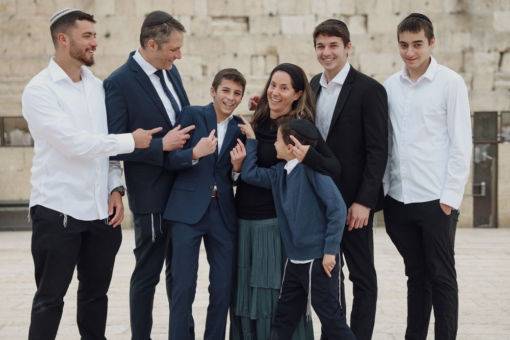 Happy Jewish family posing and laughing together at the Western Wall plaza.