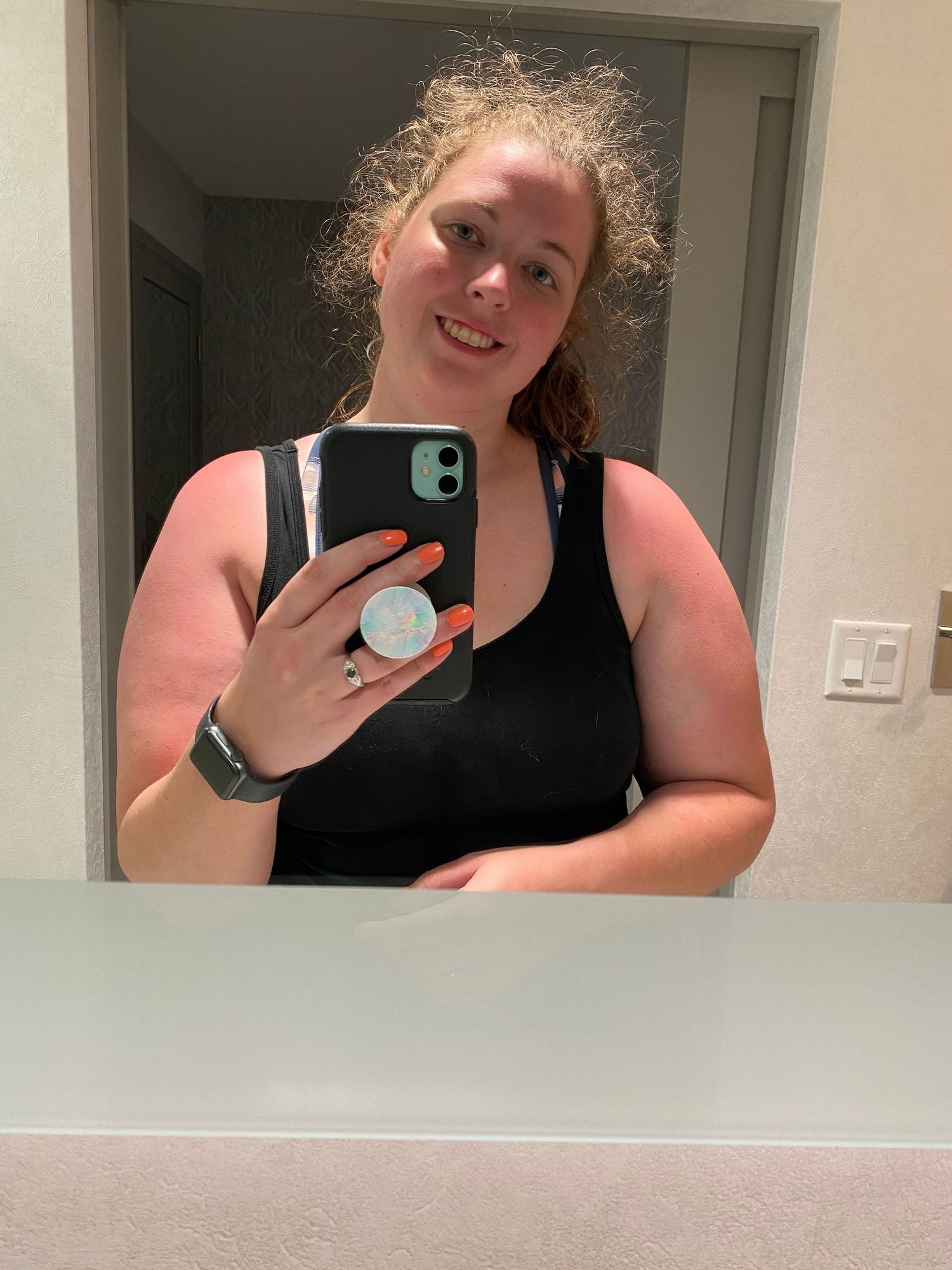 Mirror selfie showing a casual outfit and curly hair.