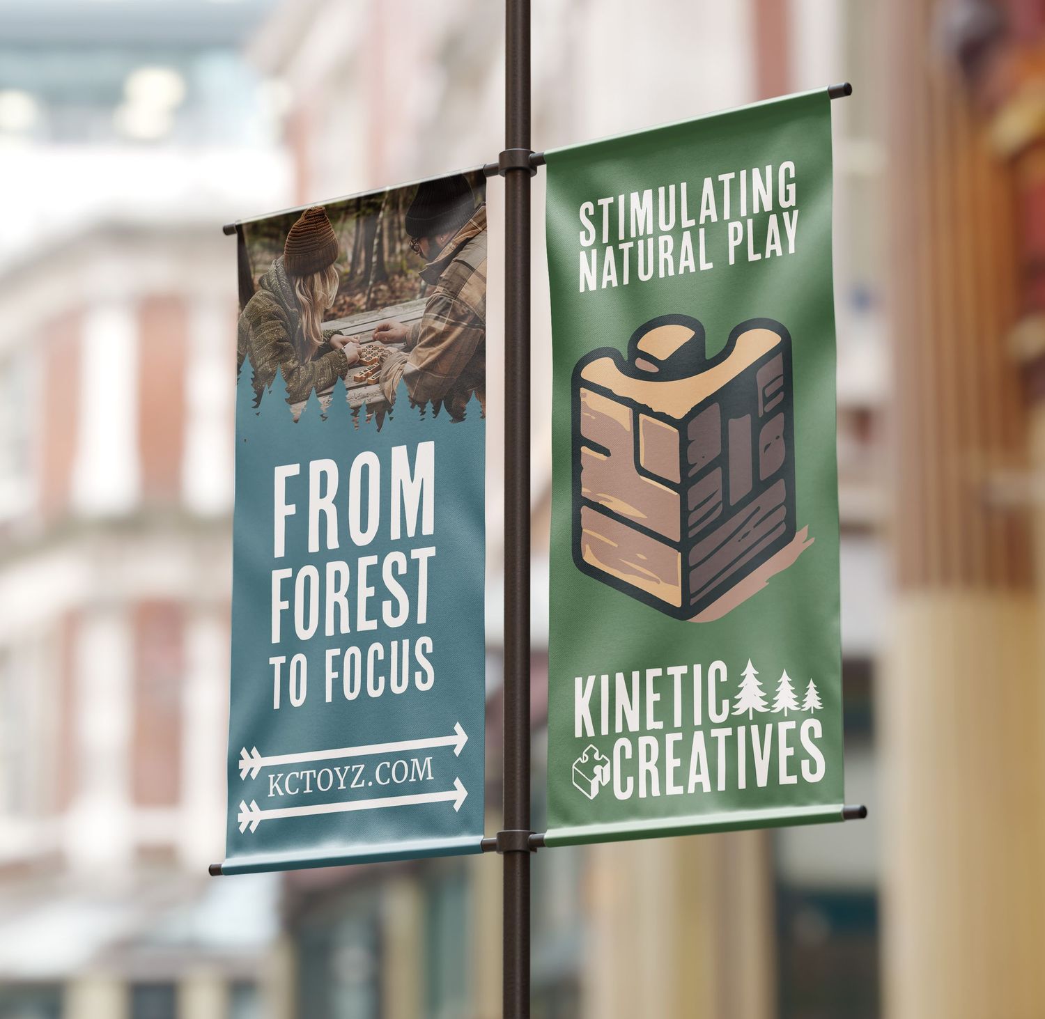 Street-mounted promotional banners for Kinetic Creatives featuring forest themes and wooden block imagery.