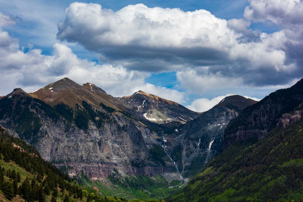 Dramatic mountain landscape with waterfalls and cloudy sky in Telluride, Colorado.