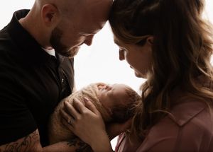 Charlottesville photographer, backlit parents and newborn baby enjoy a quiet, intimate moment at Somerset Portraits studio.