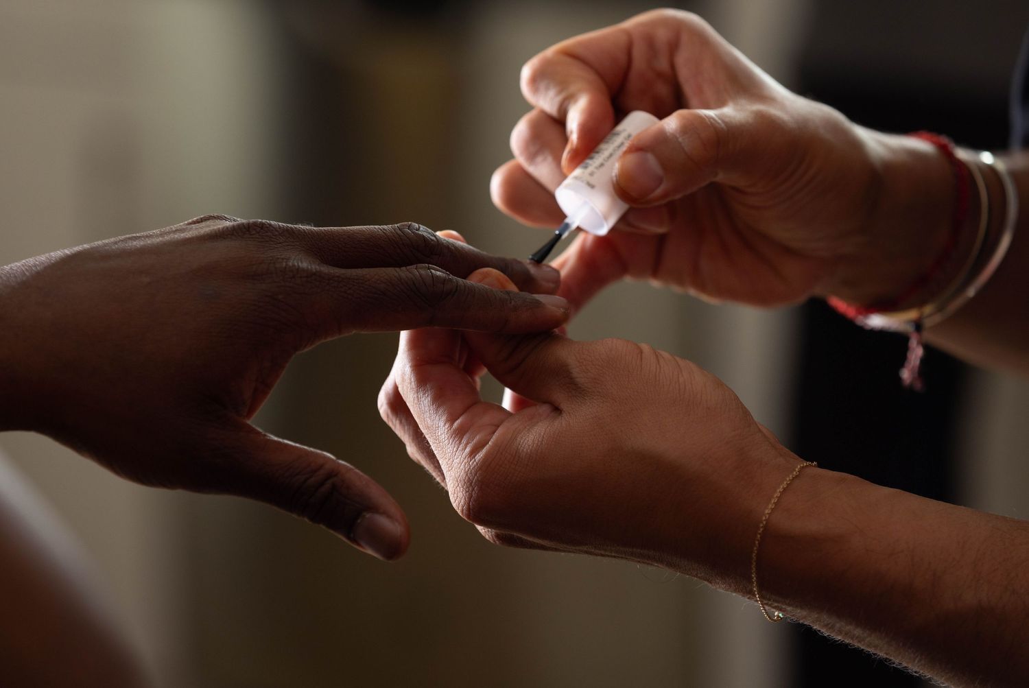 Man getting his hands touched up by makeup artist before starting a boudoir photo shoot.