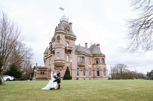 Grand Victorian mansion with ornate architecture photographed from the sweeping lawn on an overcast day.