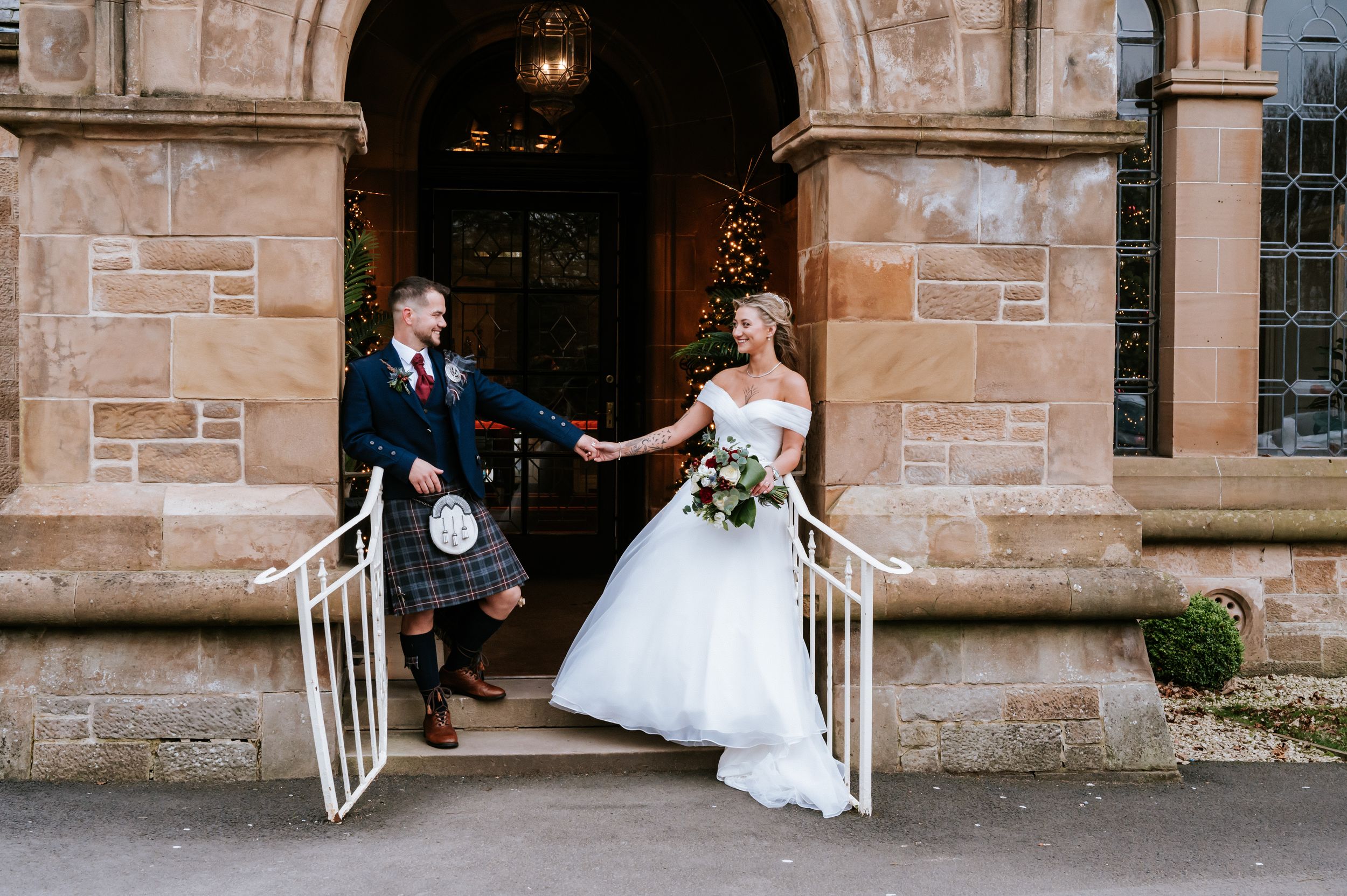 A series of four romantic wedding photos taken in front of a stone building with elegant architectural details.