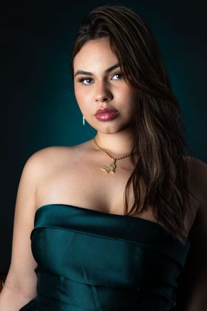 Fashion portrait series with teal evening dress against dark dramatic lighting.
