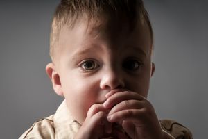 Close-up black and white portrait showing intense eyes in dramatic lighting of a toddler.