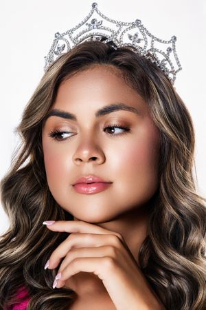 Close up beauty shots with sparkly crown and wavy hair against white background.