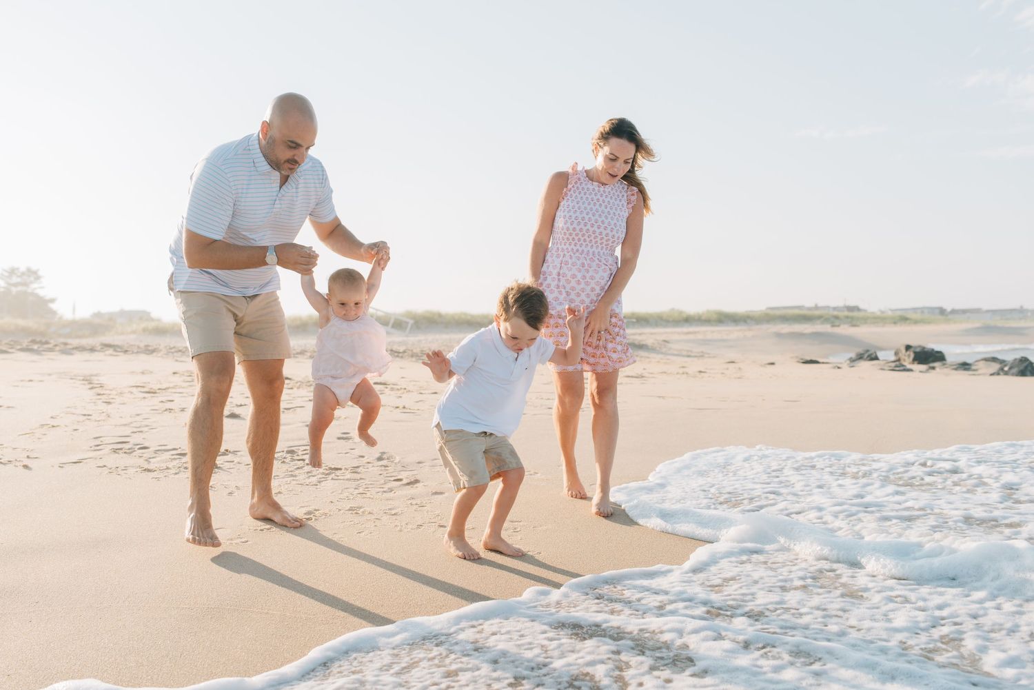 Children run and jump into the ocean at the beach in new jersey.