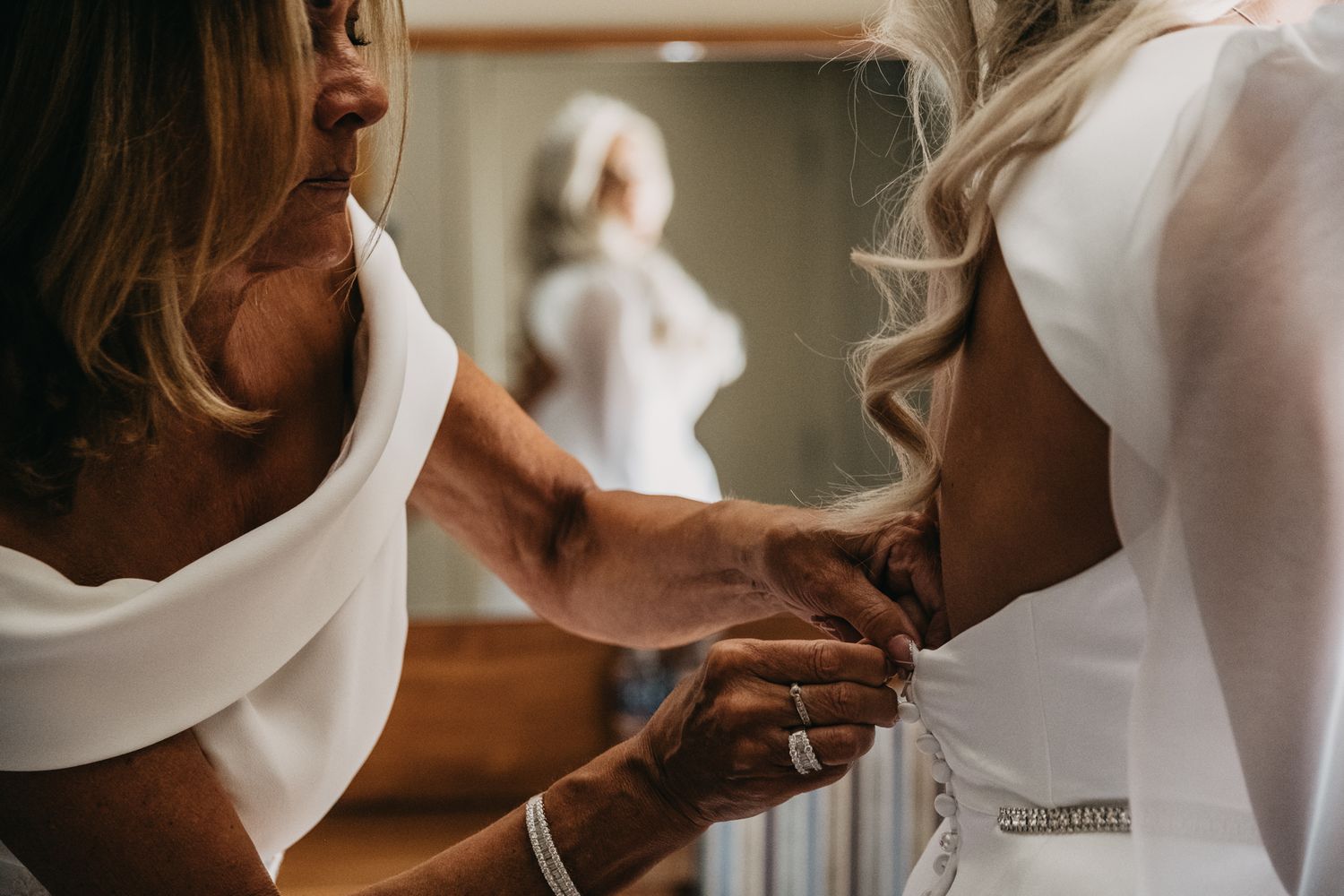 Close-up detail shots of a bride's dress and hands during an intimate wedding ceremony.