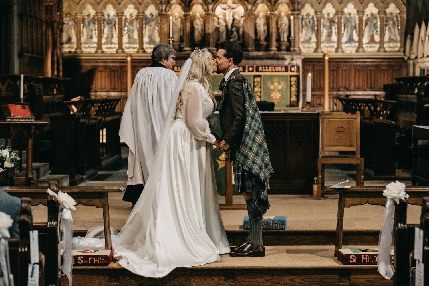 Wedding ceremony inside ornate church with stunning architectural details and stained glass.