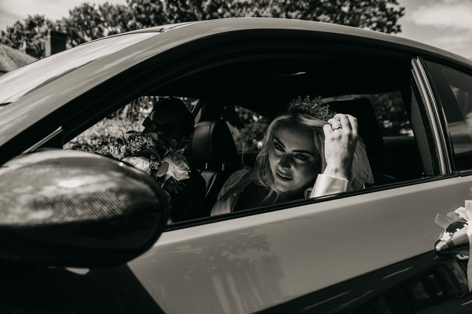 A black and white photograph of a joyful passenger in a car expressing excitement and laughter.