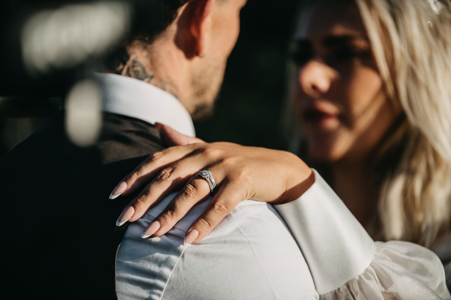 A close-up shot capturing hands embracing during an intimate moment in soft lighting.