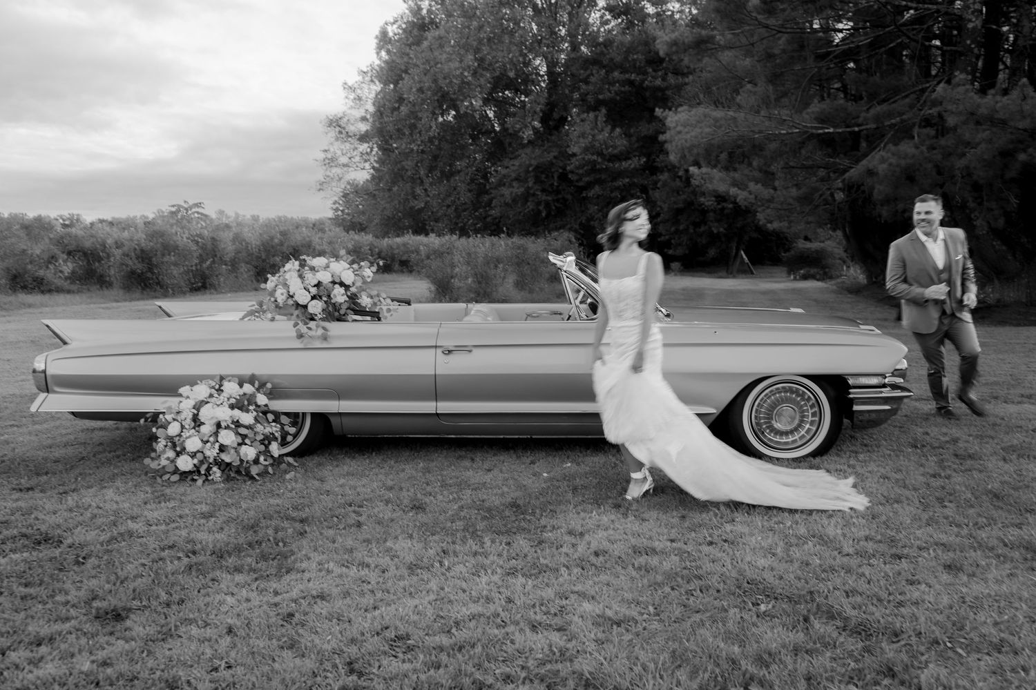 Classic vintage cars line up for an elegant outdoor wedding celebration.