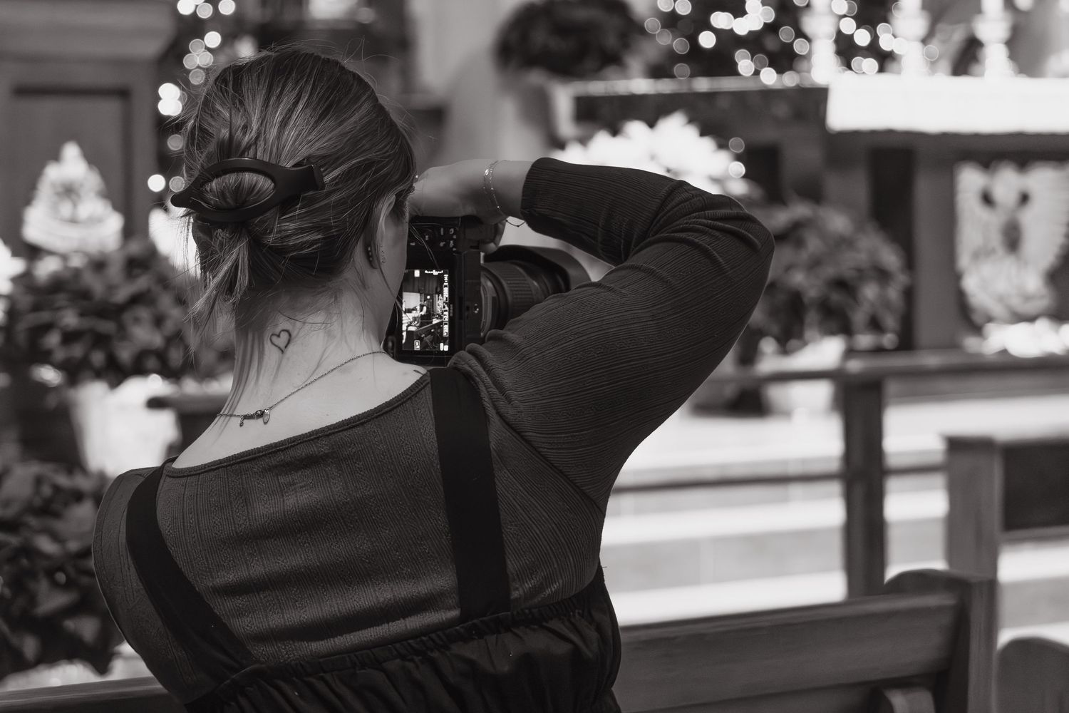 Black and white candid shot of the photographer at a wedding reception.