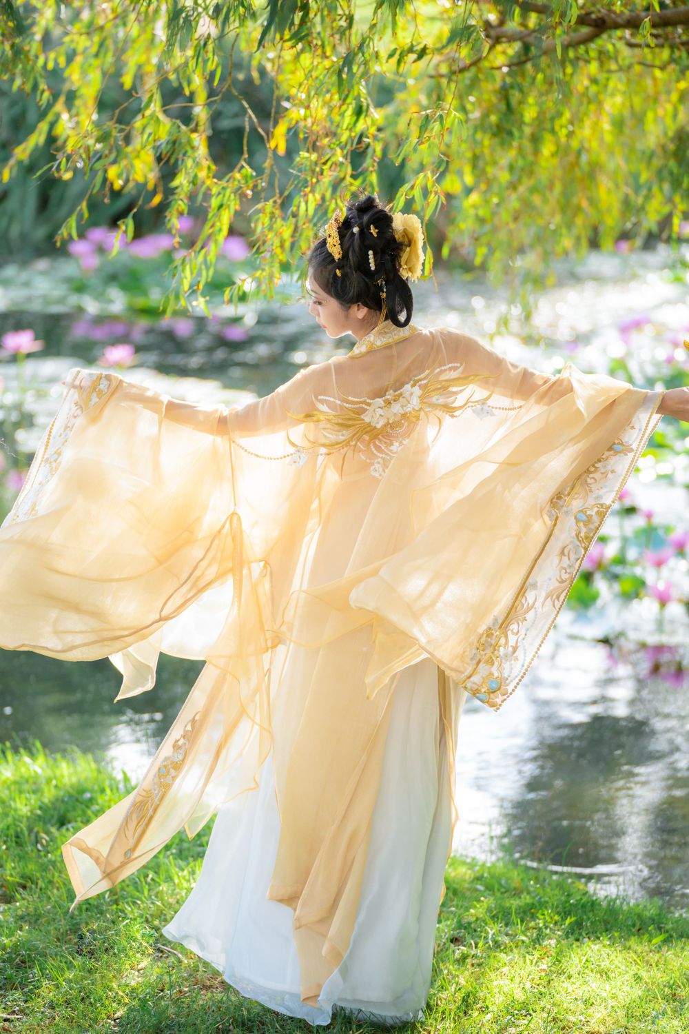 Serene solo portrait in a glowing golden Hanfu by a tranquil North Shore water lily lake, by Auckland photographer Imagine Image Studio.