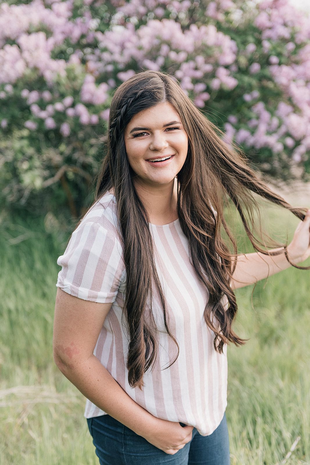 Portrait in spring with blooming pink magnolia flowers in the background.
