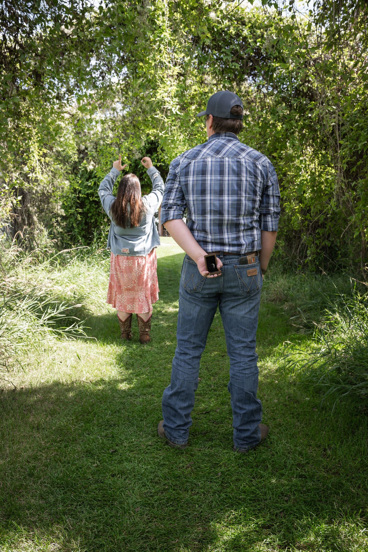 Parent and child enjoy a peaceful moment together in a lush green garden path.