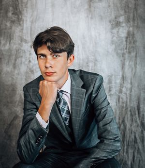 Thoughtful posed portrait shots of someone wearing a business suit in a studio setting.