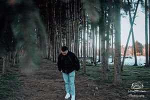 Person walking through a misty forest path wearing casual clothing.