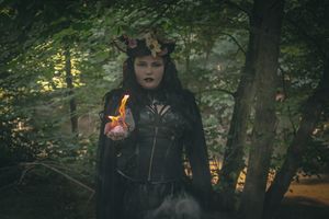 Gothic-themed figure walking through a misty forest with atmospheric lighting effects.