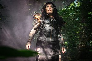 Dark-themed forest photography with figure surrounded by pink smoke effects.