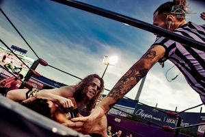 Professional wrestling match action shot with dramatic camera angle.