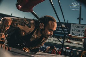 Wrestling match scene captured from ground level at outdoor venue.