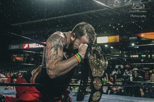 Two wrestlers grappling during an intense professional wrestling match.