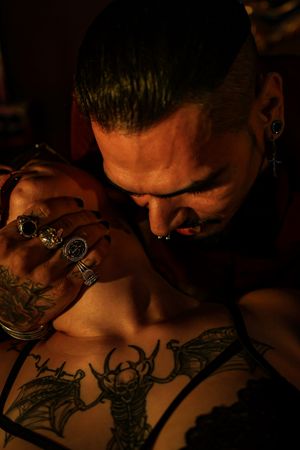 Artist works meticulously on creating a detailed tattoo design in a dimly lit studio setting.