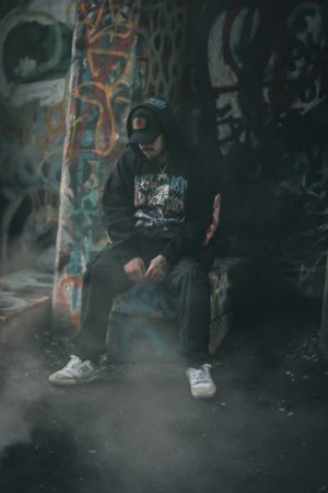 Atmospheric smoke effect around shoes and legs against graffiti wall background.
