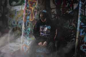 Moody smoke effects in dark setting with graffiti wall backdrop.