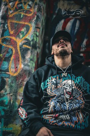 Artistic street fashion photography featuring hoodie with detailed graphic design.