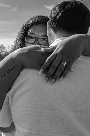 Black and white photo sequence showing hands tenderly touching shoulders in an intimate embrace.