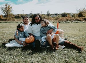 A sequence of five photos showing a couple laying in a grassy field with pumpkins during an autumn photoshoot.