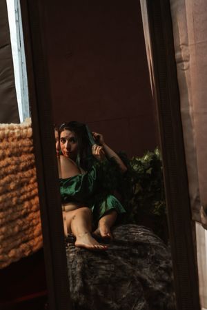 Person lying on textured surface in moody lighting with architectural columns visible.