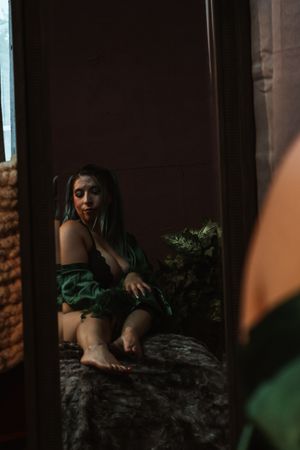 Person in dark room illuminated by soft natural light through window or doorway.