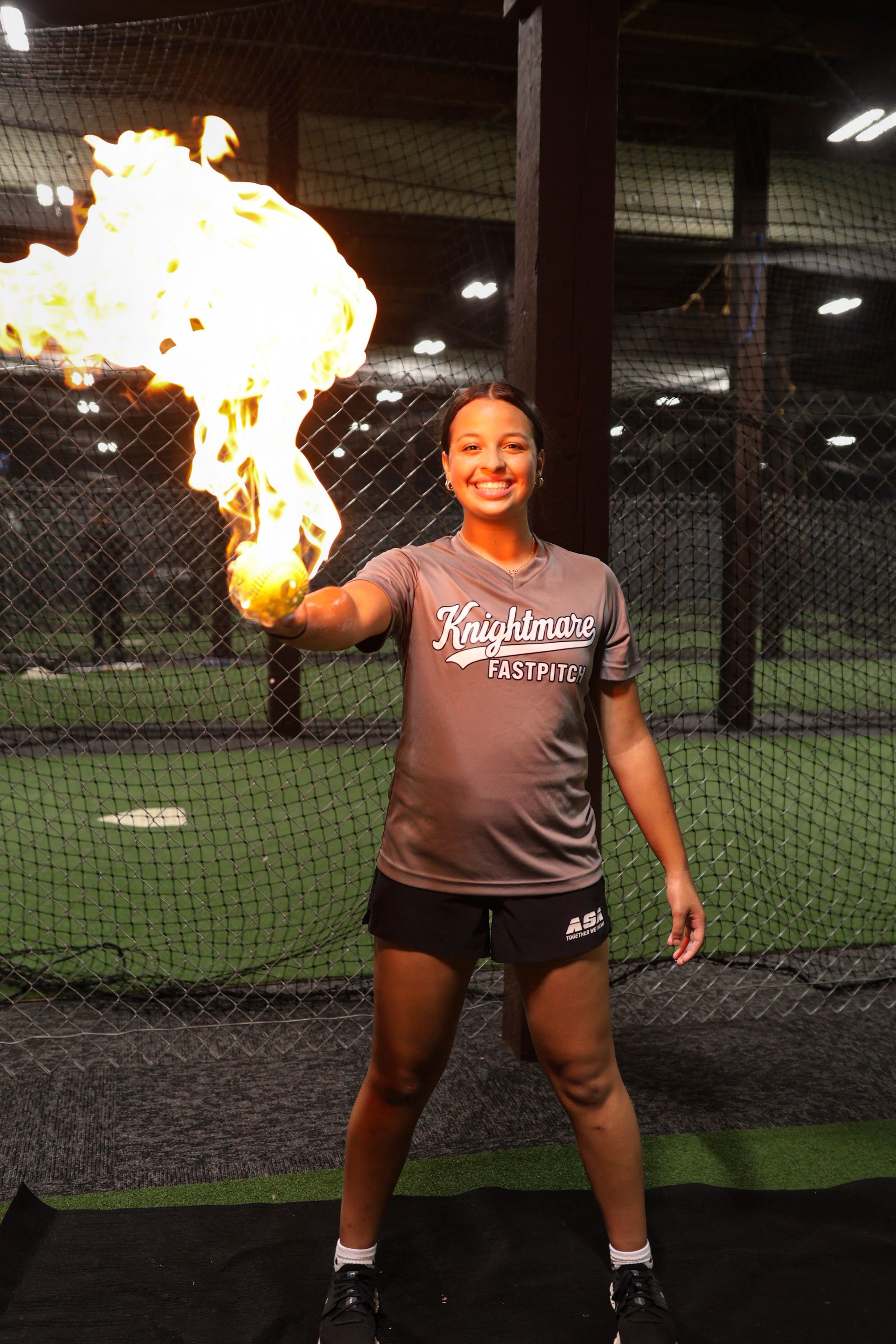 Sequence of action shots showing a softball player in a brown uniform making a dynamic pitching motion with flames visible.