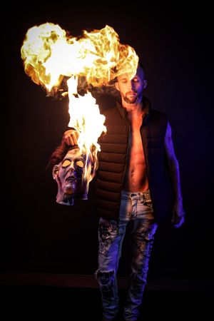 Fire performance art demonstrates controlled flame effects in dramatic lighting.