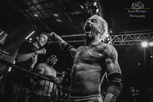 Intense wrestling action captured in dramatic black and white at arena event.
