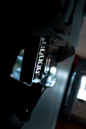 Close-up black and white detail of an electric guitar volume control knob.