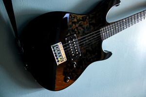 Black electric guitar with pickguard and hardware shown against light background.