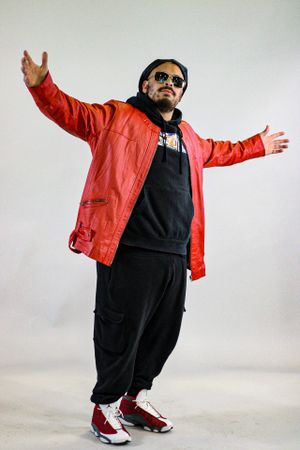 Dynamic fashion poses in red jacket and black outfit against white backdrop.
