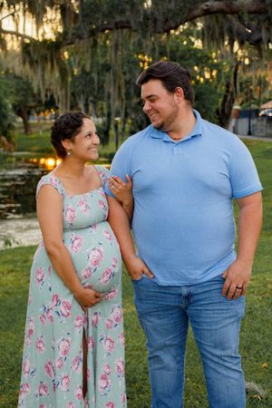 A couple shares a romantic moment in a garden setting wearing coordinating blue and floral outfits.
