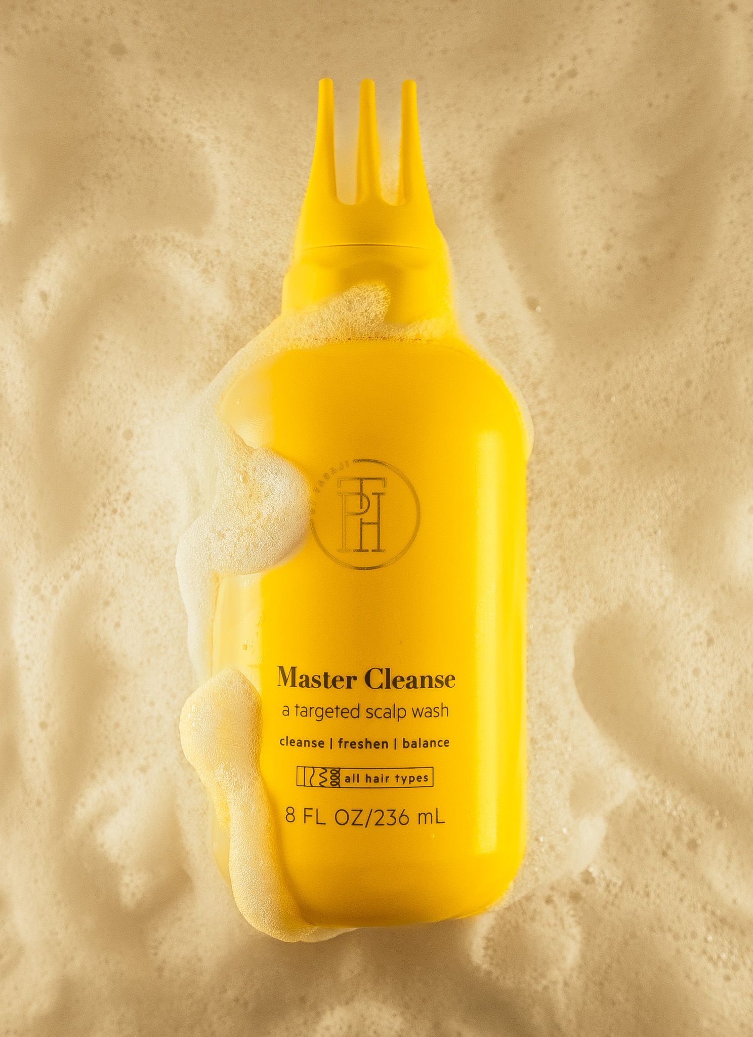 Master Cleanse bottle with foam bubbles floating against beige textured background.