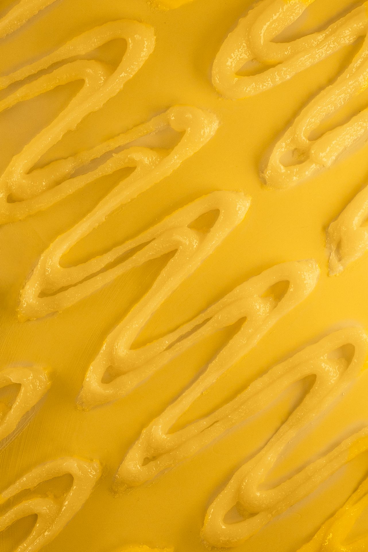 Close-up of wavy yellow textured pattern background with diagonal lines.