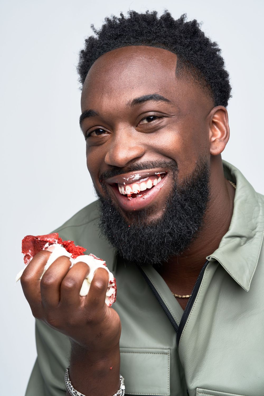 Close-up shots of person enjoying a strawberry dessert while wearing olive green shirt.