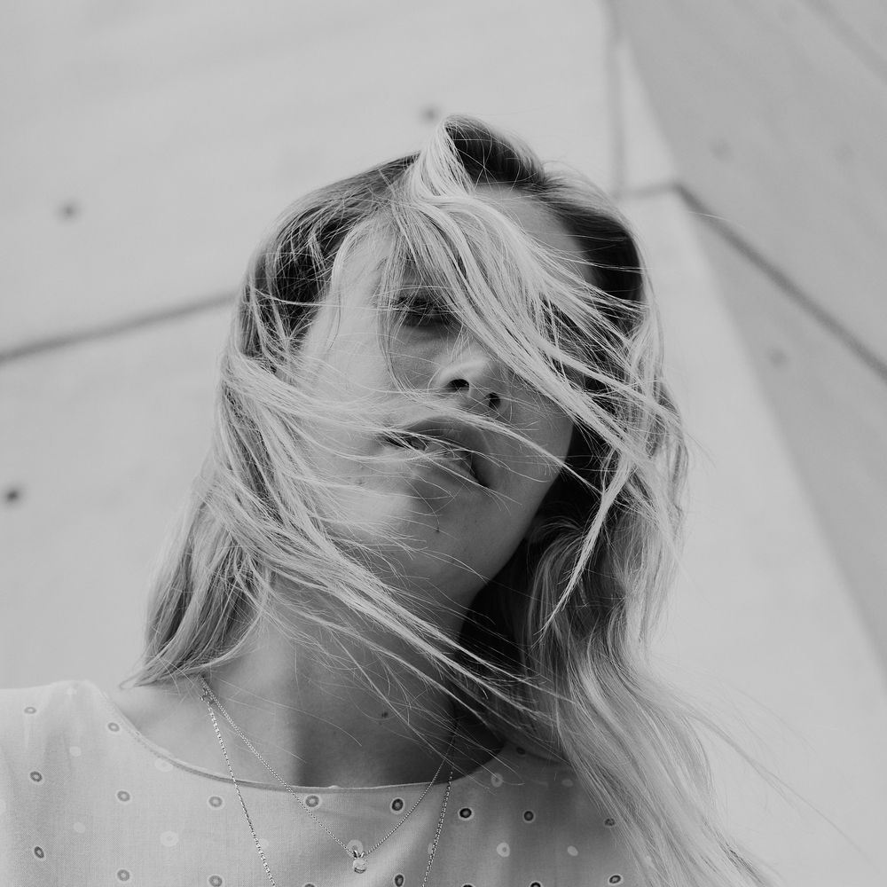 Artistic black and white portrait series showing flowing blonde hair against white background.