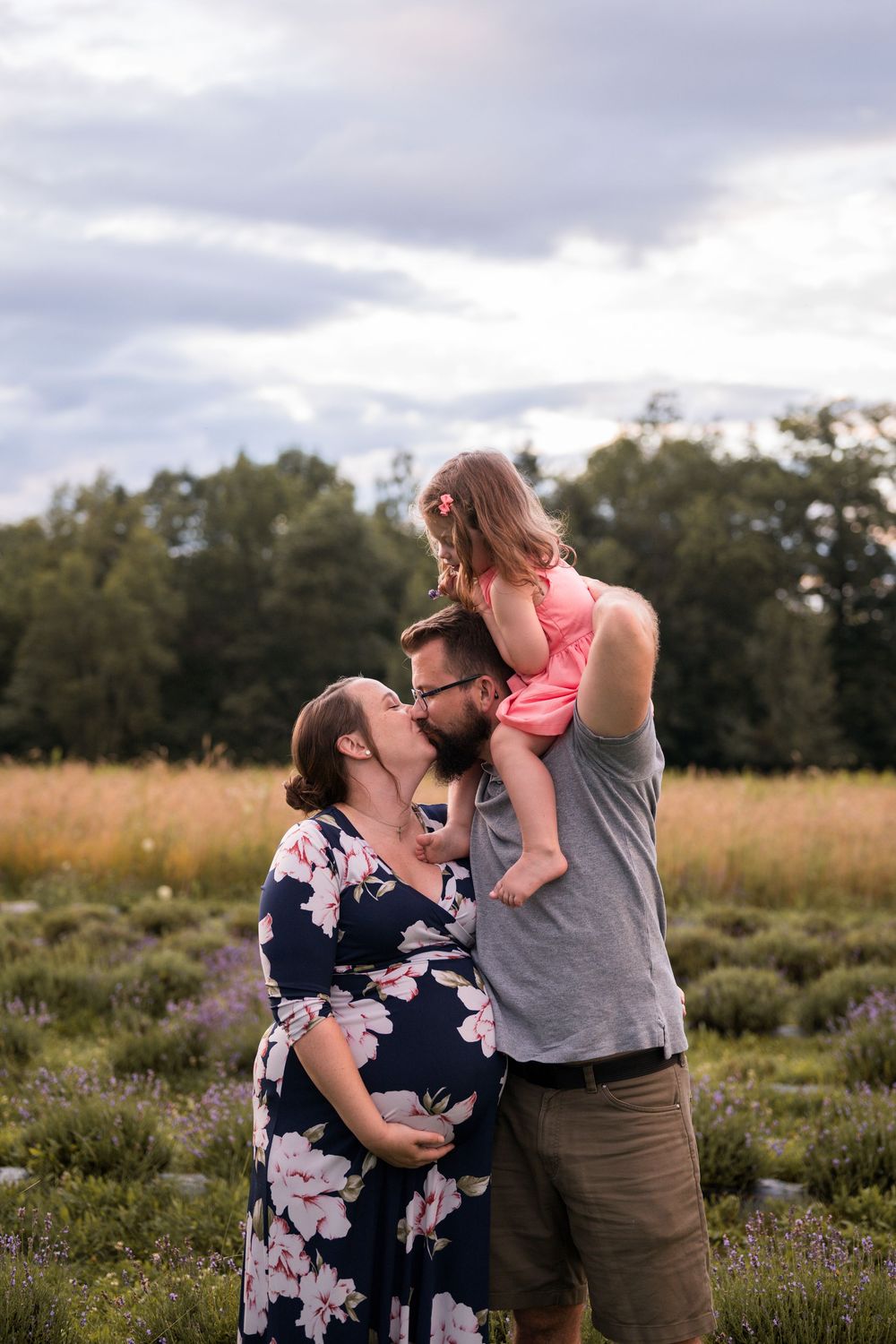 A family shares tender moments together in a wildflower field during golden hour.