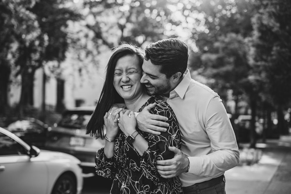A joyful moment captured between a couple during their engagement session on a city street.
