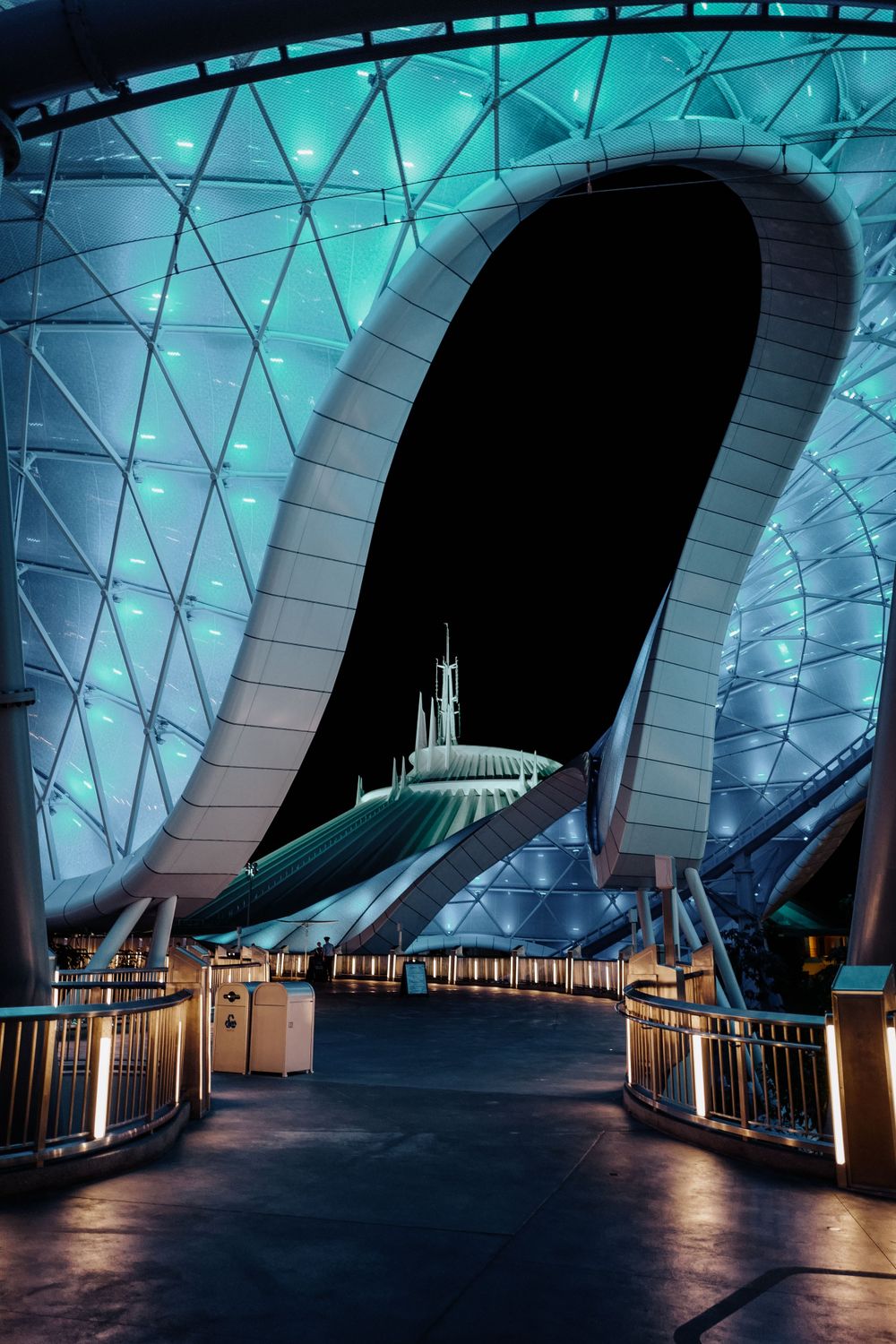 Futuristic blue-lit architecture of Space Mountain at Disney theme park at night.